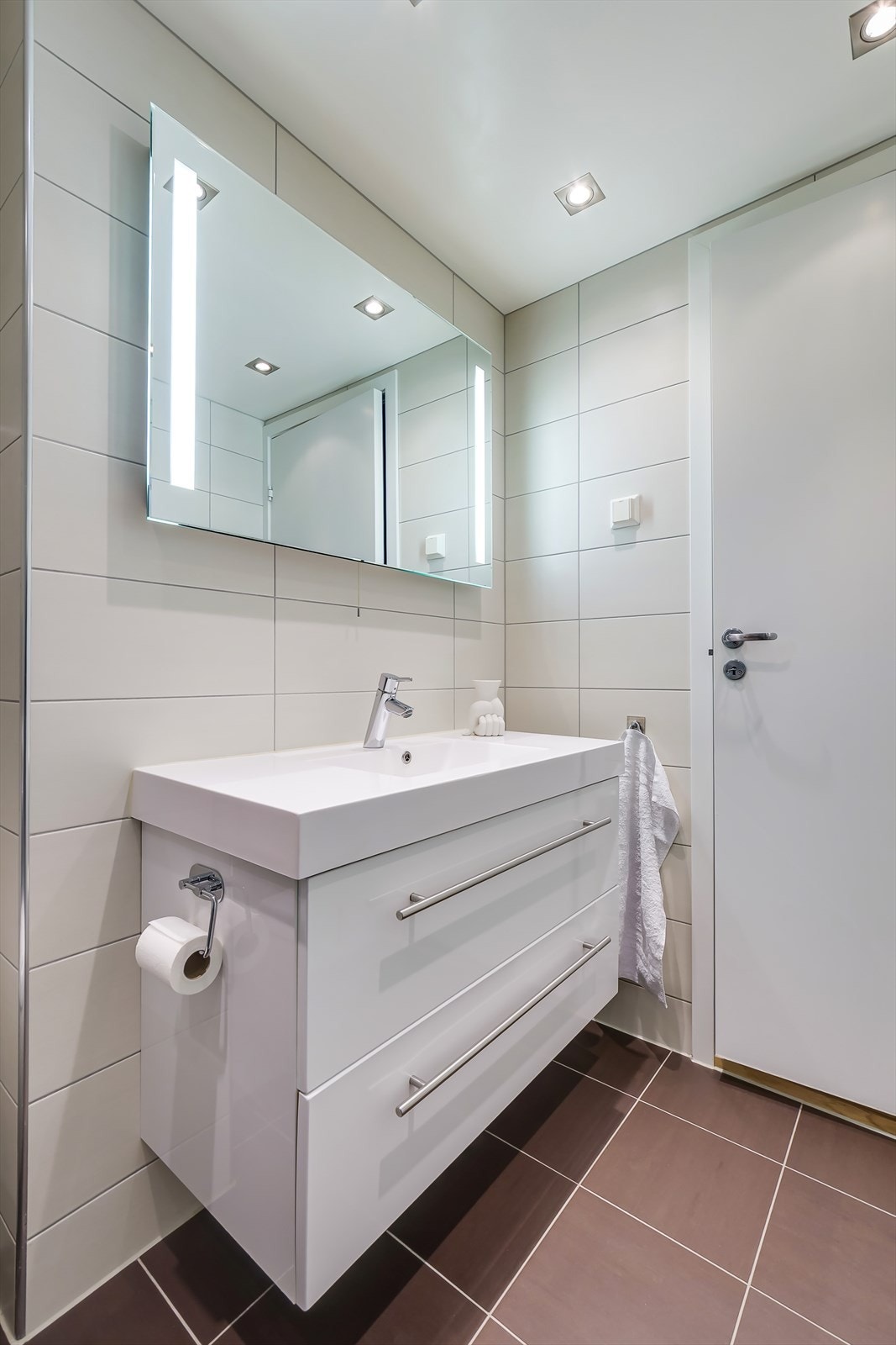 Badet er utstyrt med servant, vegghengt toalett, dusjvegger og opplegg for vaskemaskin. Galleribilde