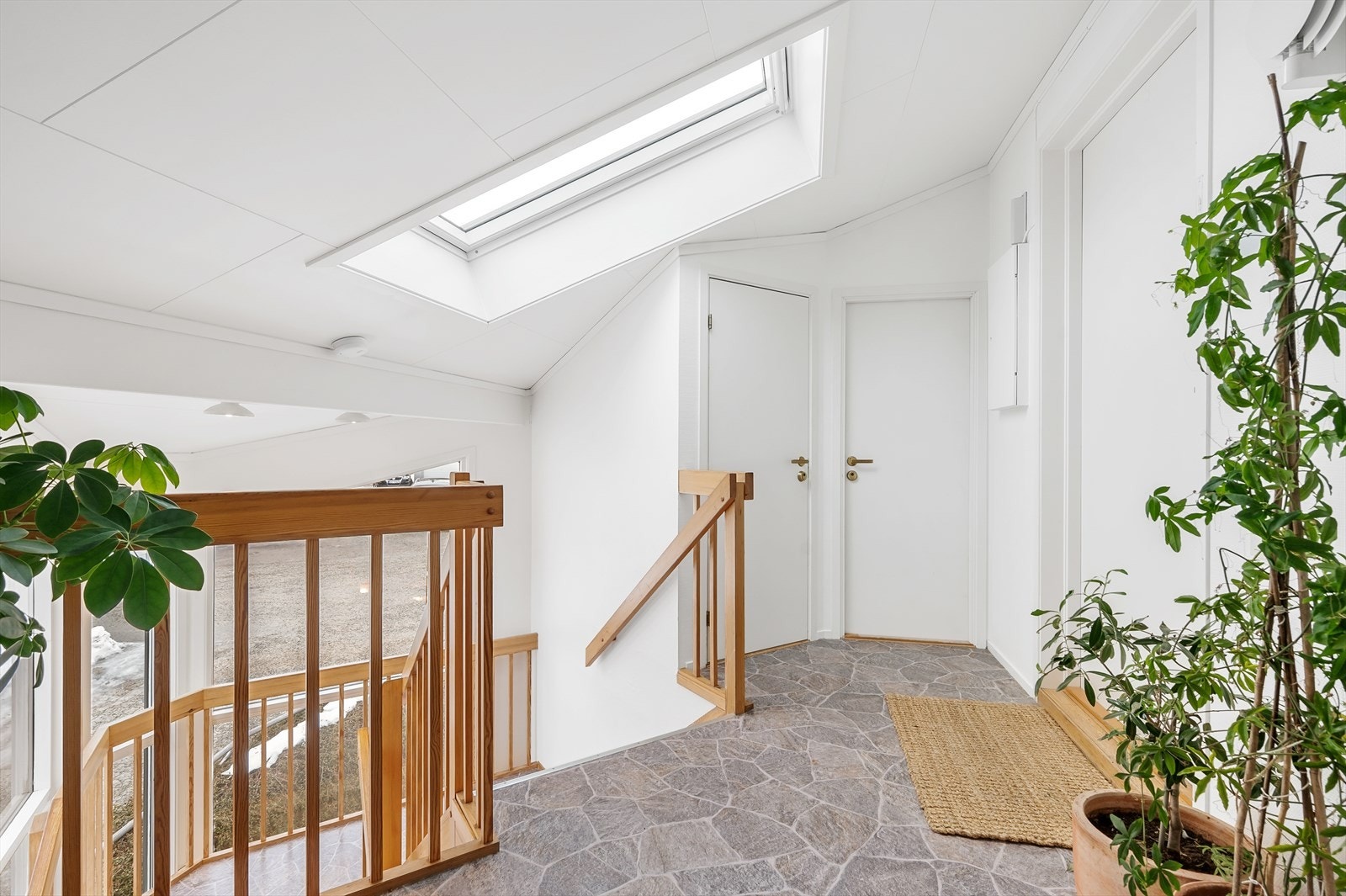 Hyggelig inngangsparti med store vindusflater og lysfelt i tak, dør til venstre i bildet inneholder bod/vaskerom til denne leiligheten. Galleribilde