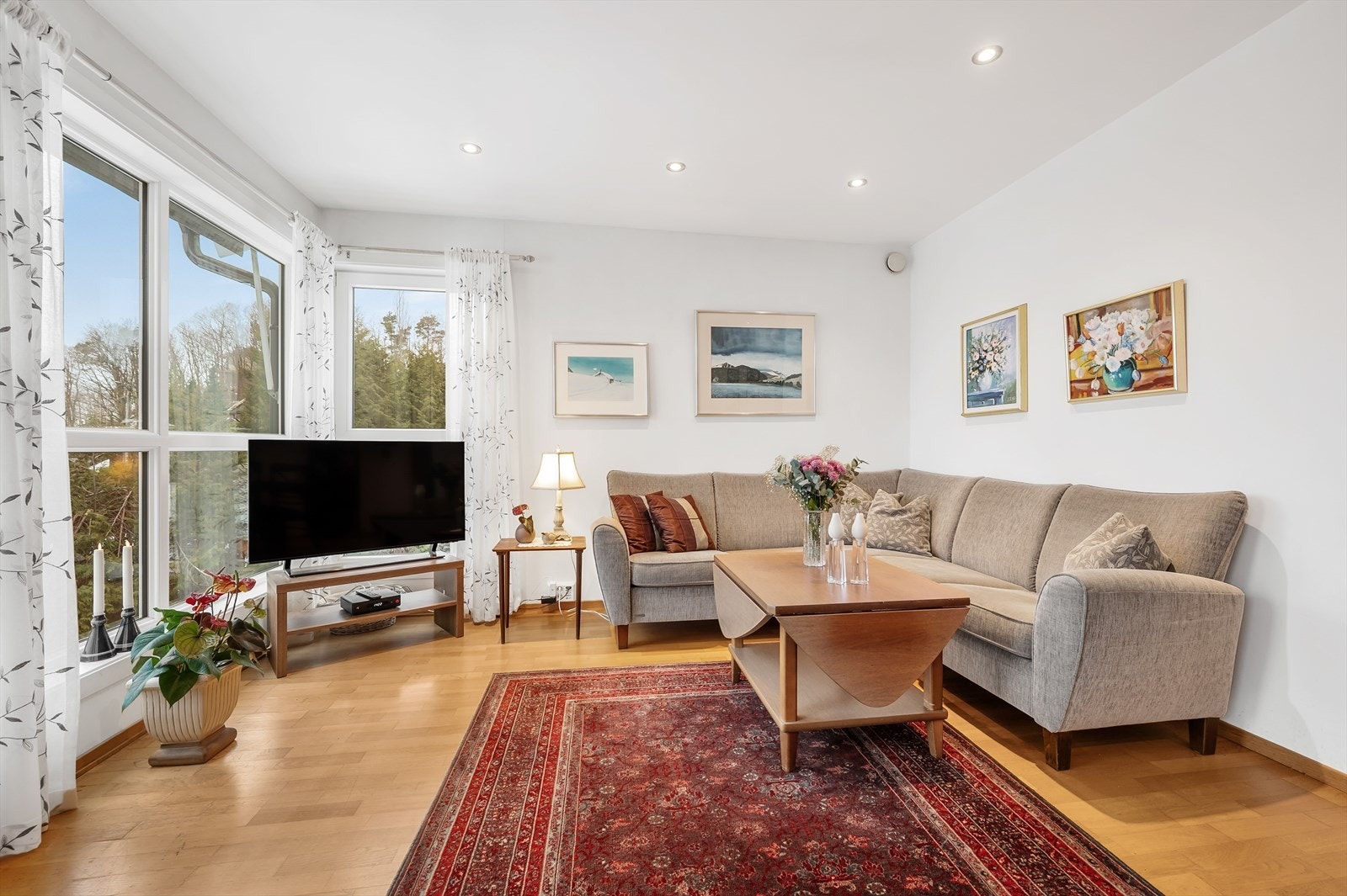 Lys og fin stue/spisestue med store vindusflater og utgang til terrasse Galleribilde