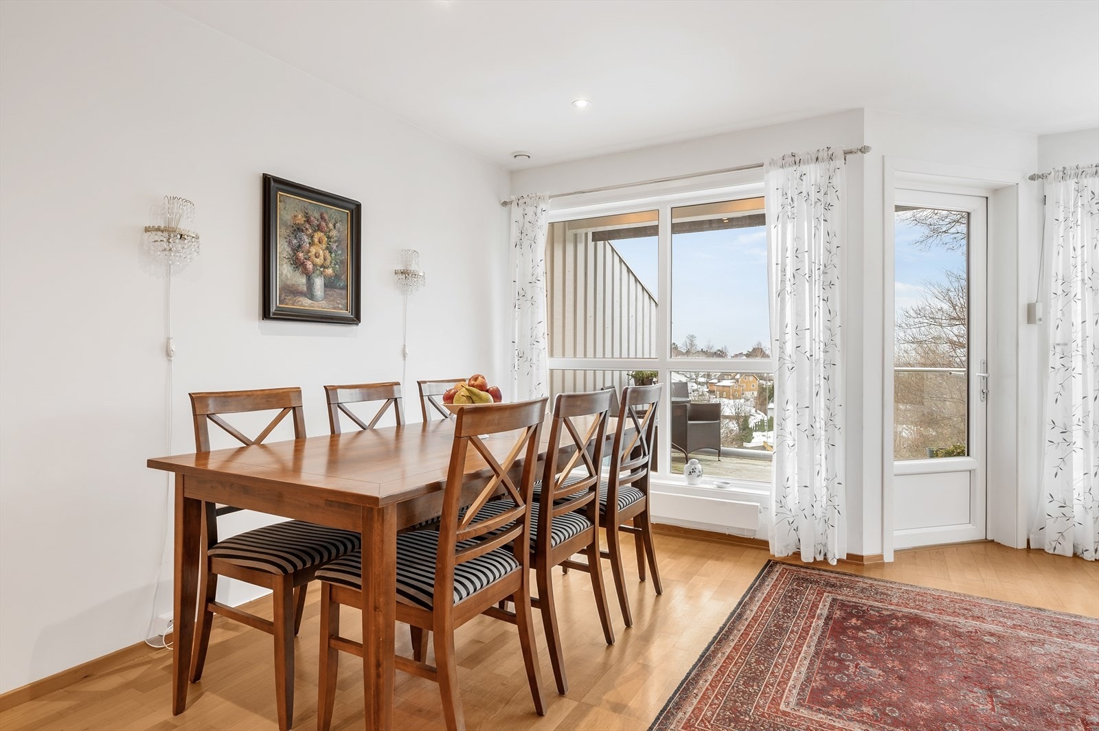 Lys og fin stue/spisestue med store vindusflater og utgang til terrasse Galleribilde