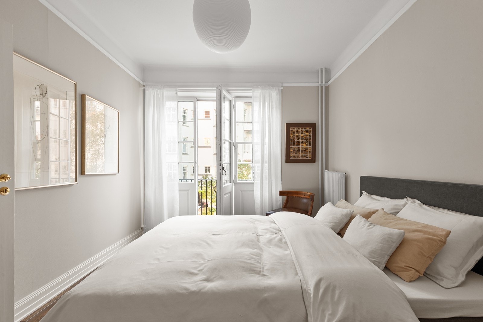 Romslig hovedsoverom med plassbygde takhøye skap og fransk balkong med store foldedører Galleribilde