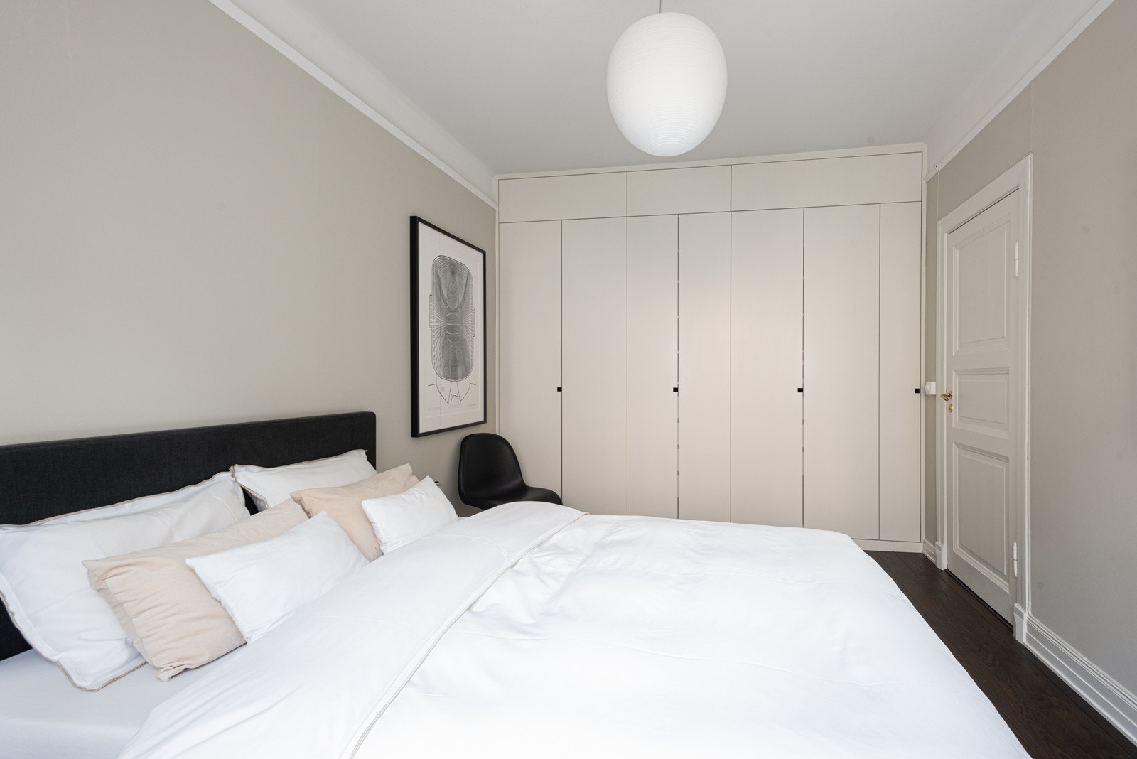 Romslig hovedsoverom med plassbygde takhøye skap og fransk balkong med store foldedører Galleribilde