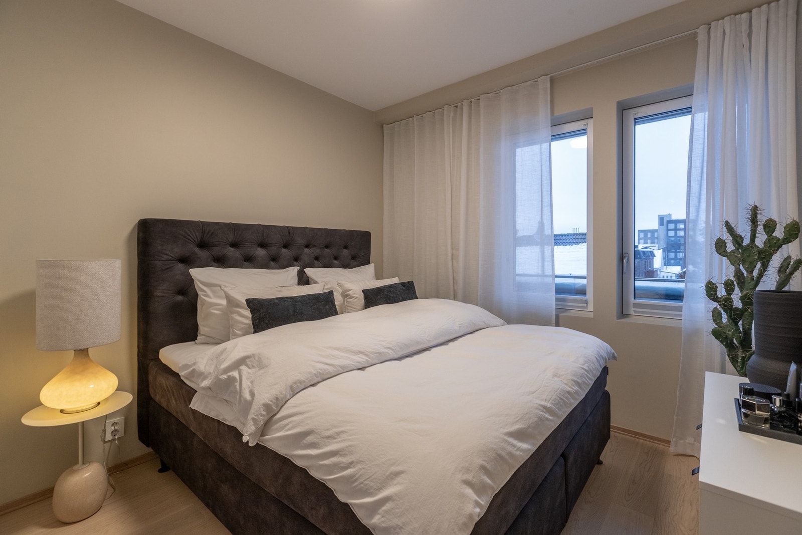 Lyst og trivelig soverom med skyvedørsgarderobe Galleribilde