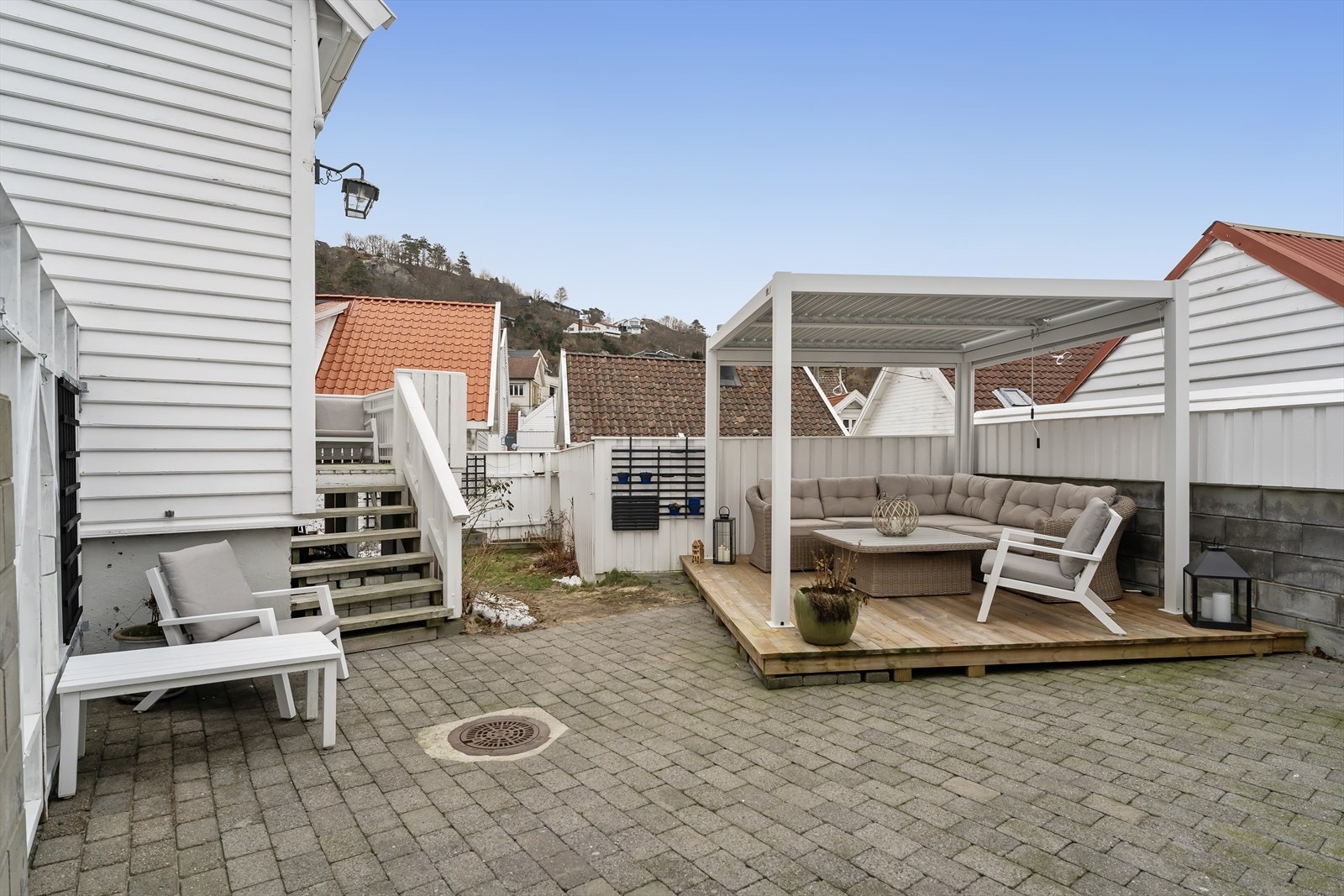 Fin uteplass med steinbelagte områder og hage med plen Galleribilde