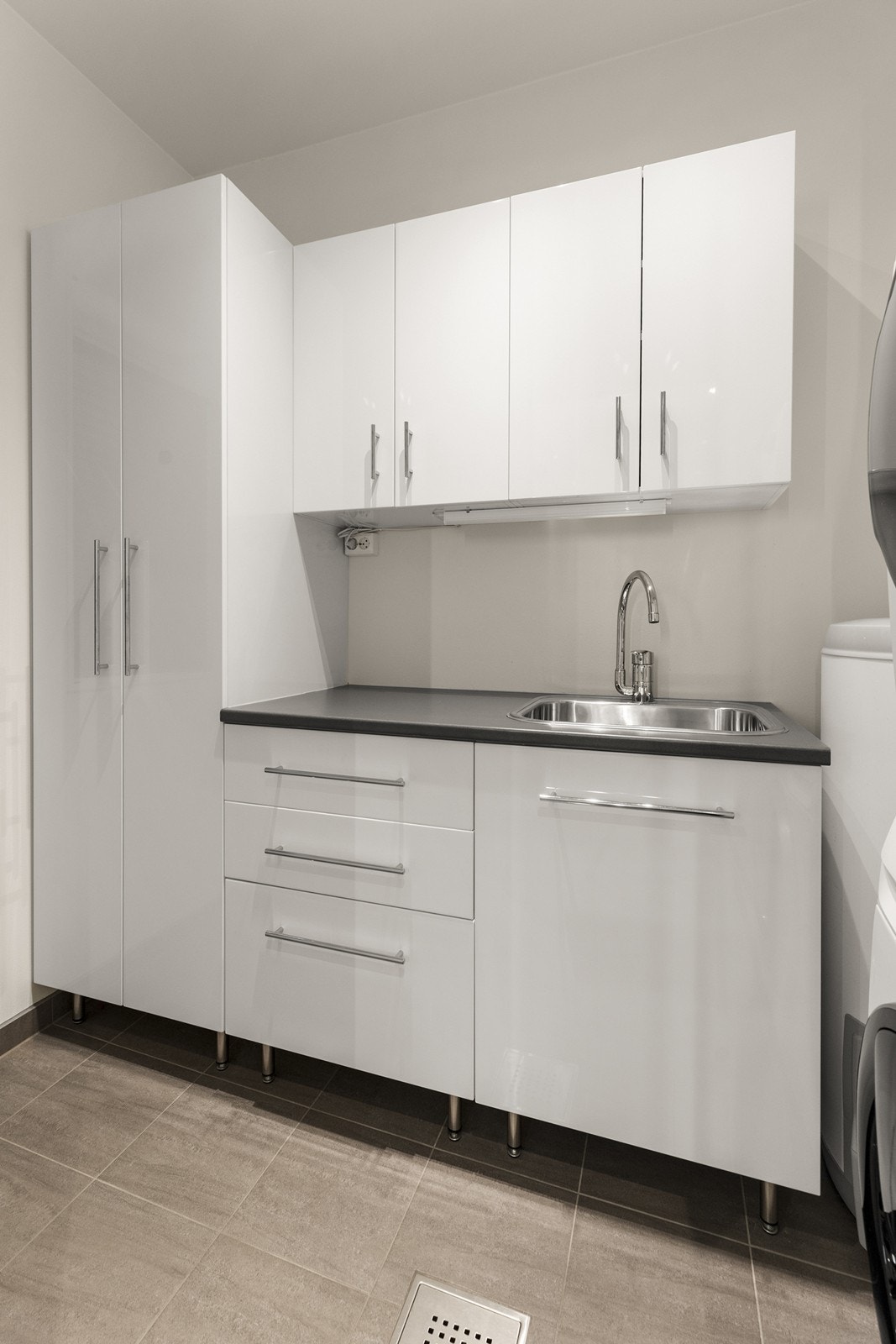 Brukervennlig vaskerom med opplegg til vaskemaskin og utslasvask Galleribilde