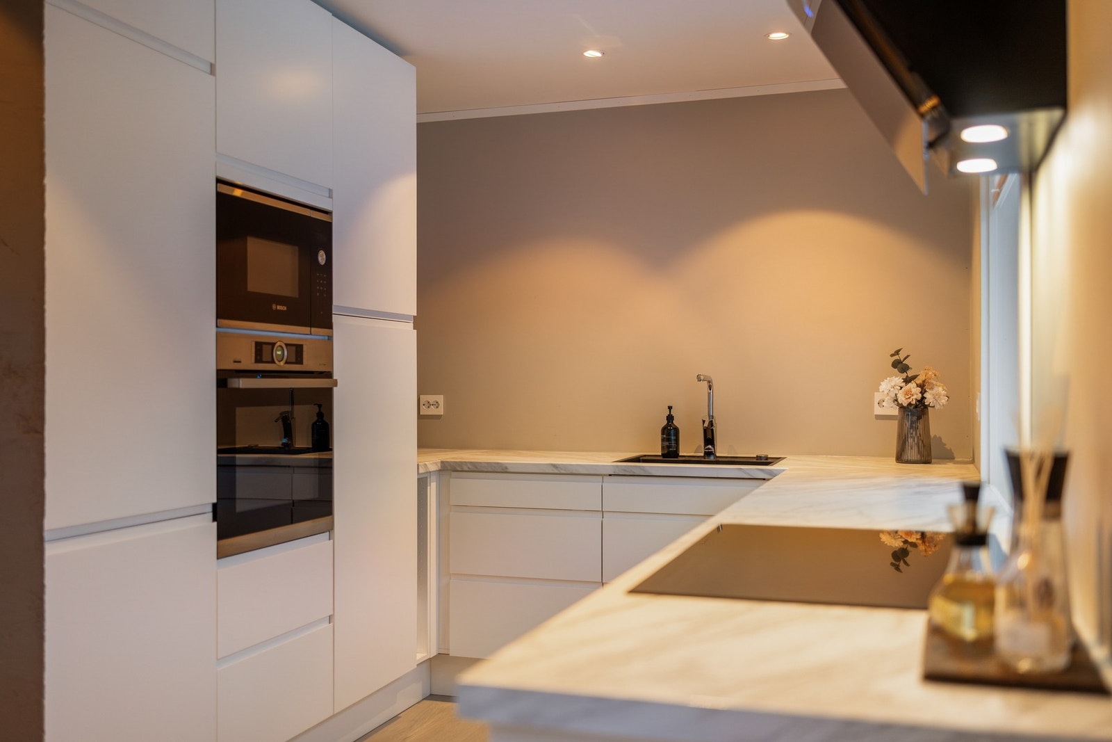 Kjøkkenet er utstyrt med integrerte hvitevarer som kjøl/fryseskap, oppvaskmaskin med vannstoppsystem, induksjonstopp med komfyrvakt, stekeovn og micro Galleribilde