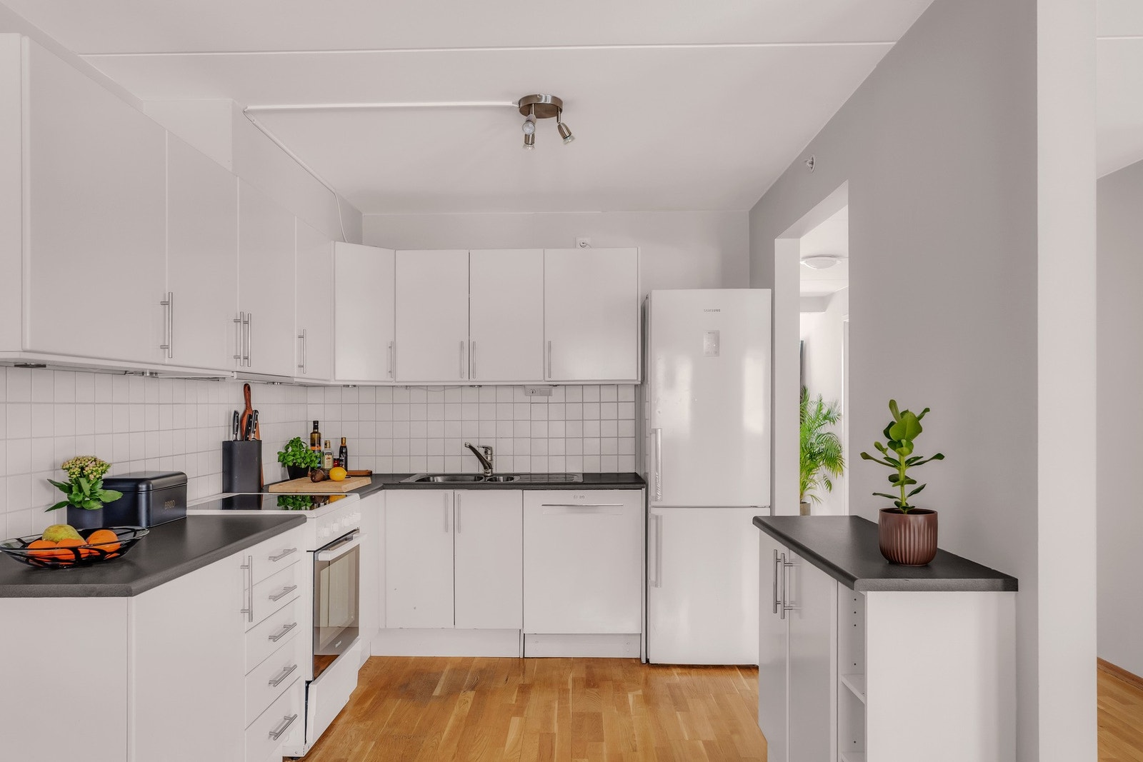 Kjøkkenet er innredet med integrerte hvitevarer som oppvaskmaskin, stekeovn, koketopp og kombiskap. Galleribilde