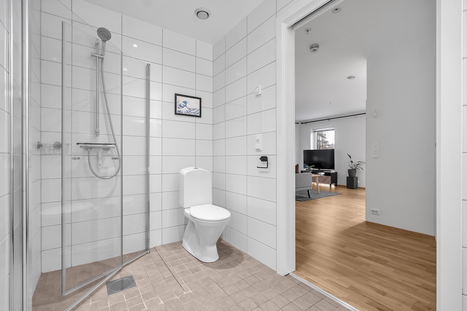 Pent flislagt bad med innredet med nedfelt servant, toalett og dusjvegger/hjørne. Galleribilde