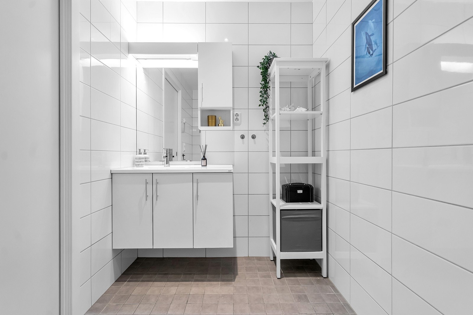 Pent flislagt bad med innredet med nedfelt servant, toalett og dusjvegger/hjørne. Galleribilde