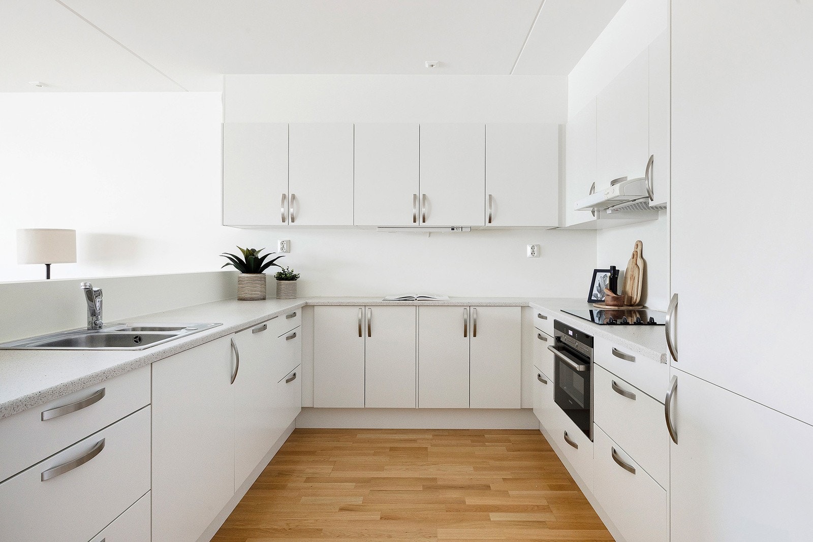 Stilrent og lyst kjøkken med integrerte hvitevarer. Galleribilde