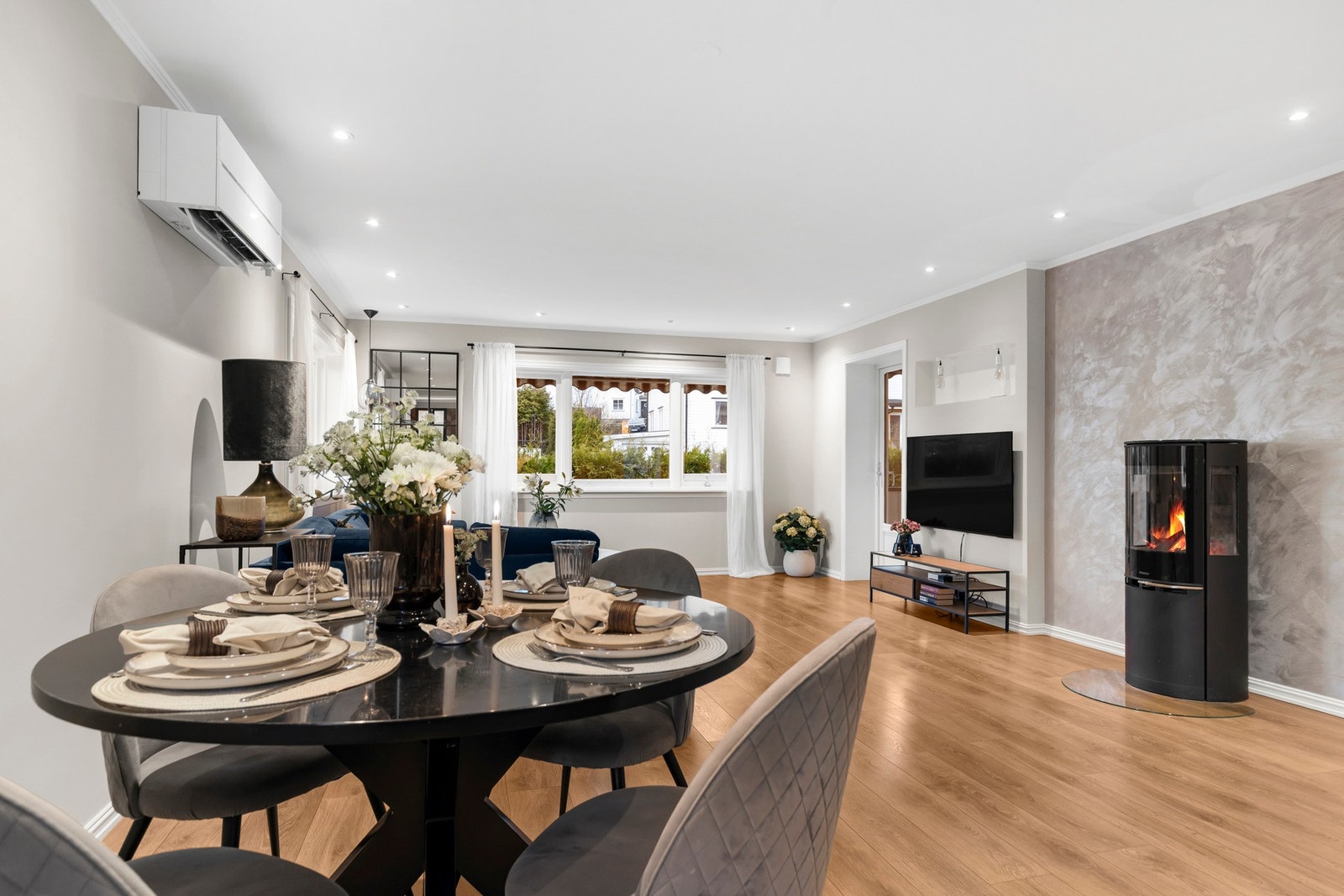 Stuen varmes effektivt opp av en moderne peisovn og varmepumpe Galleribilde