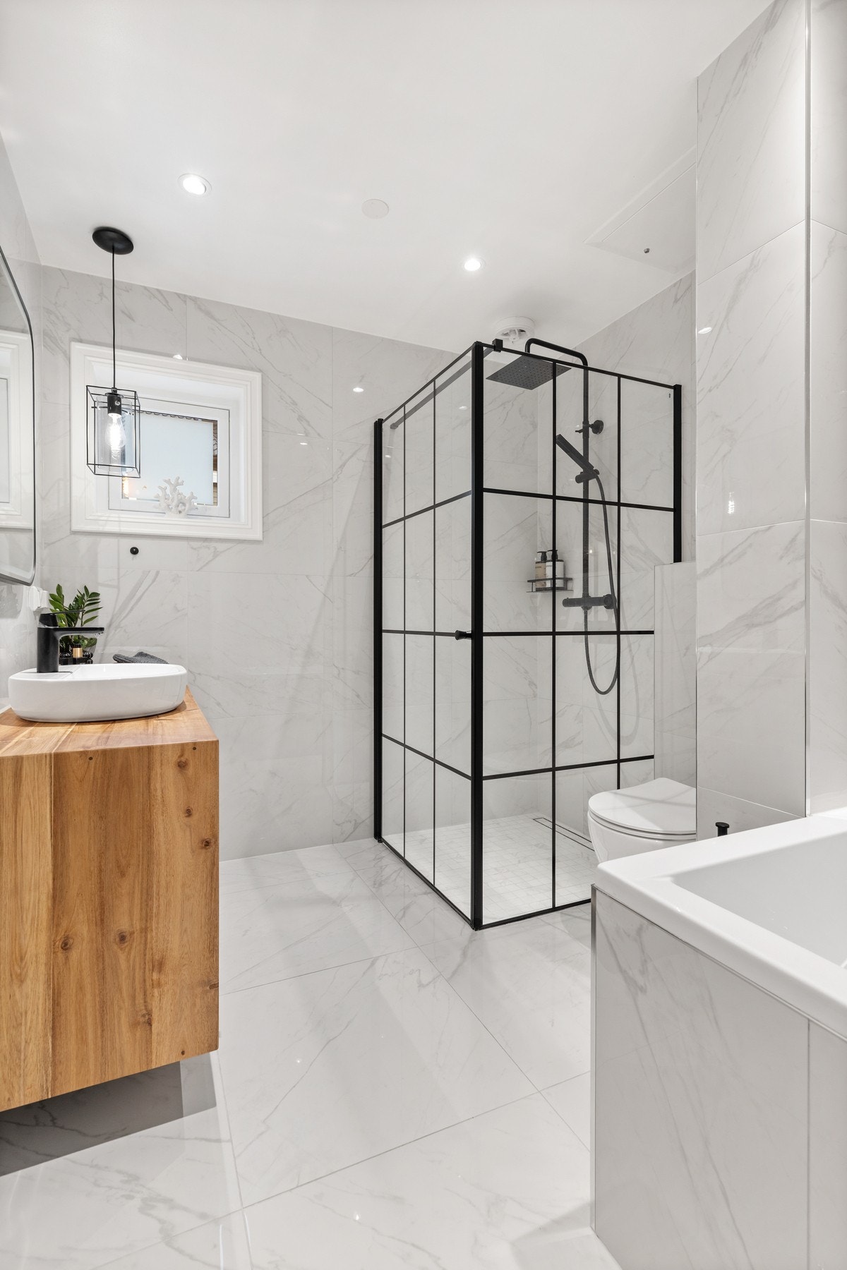 Delikat bad fra 2022 med flislagt gulv- og veggflater samt slett flate i himling Galleribilde