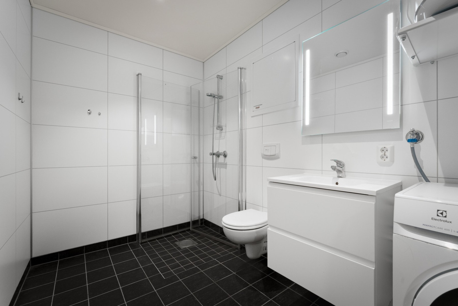 Leiligheten har et lyst og romslig bad med stilrene overflater Galleribilde