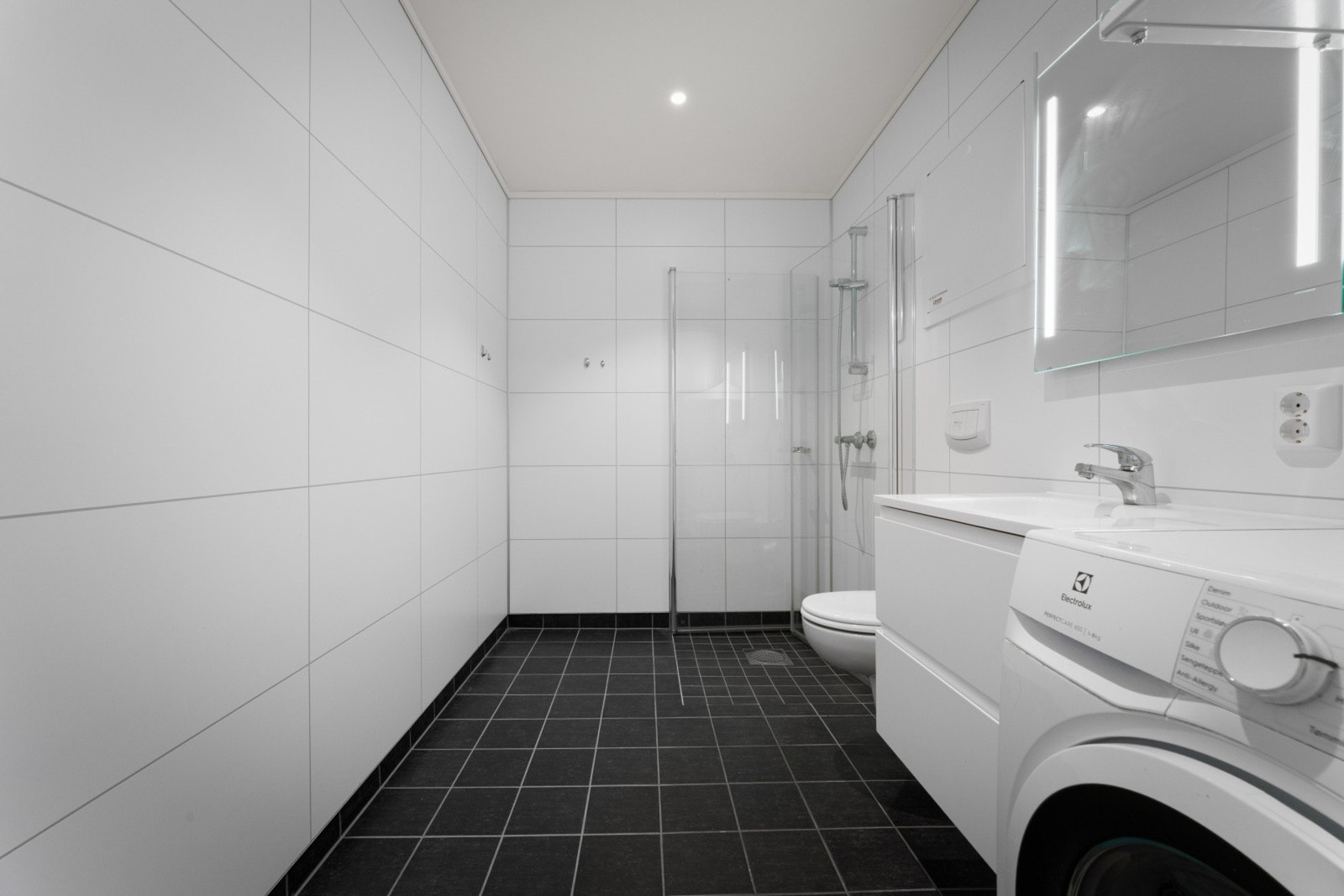 Badet er også utstyrt med innfelte downlights og opplegg for vaskemaskin Galleribilde