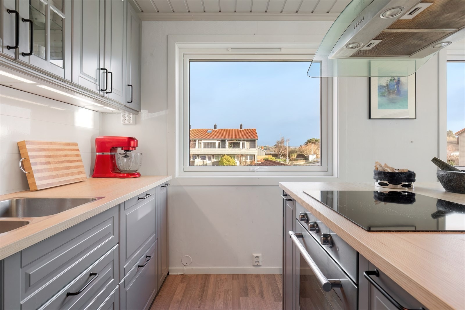 Utsyn mot nabolaget fra kjøkkenvinduet gir en lys og åpen følelse. Galleribilde