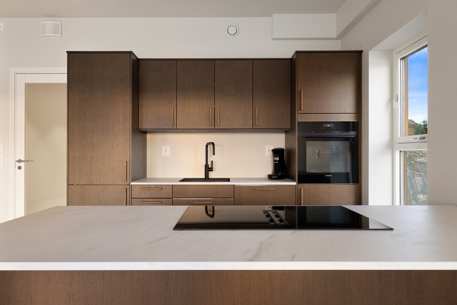 Av integrerte hvitevarer finnes her: stekeovn, induksjonstopp med integrert ventilator, oppvaskmaskin og kjøleskap med frysedel. Galleribilde