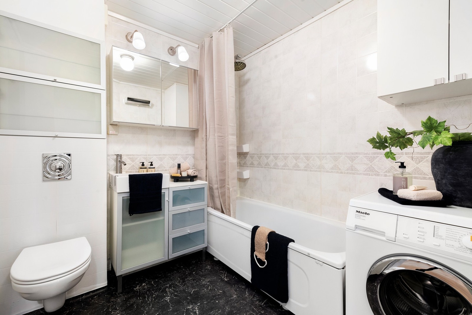 Bad med badekar og opplegg til vaskemaskin. Galleribilde