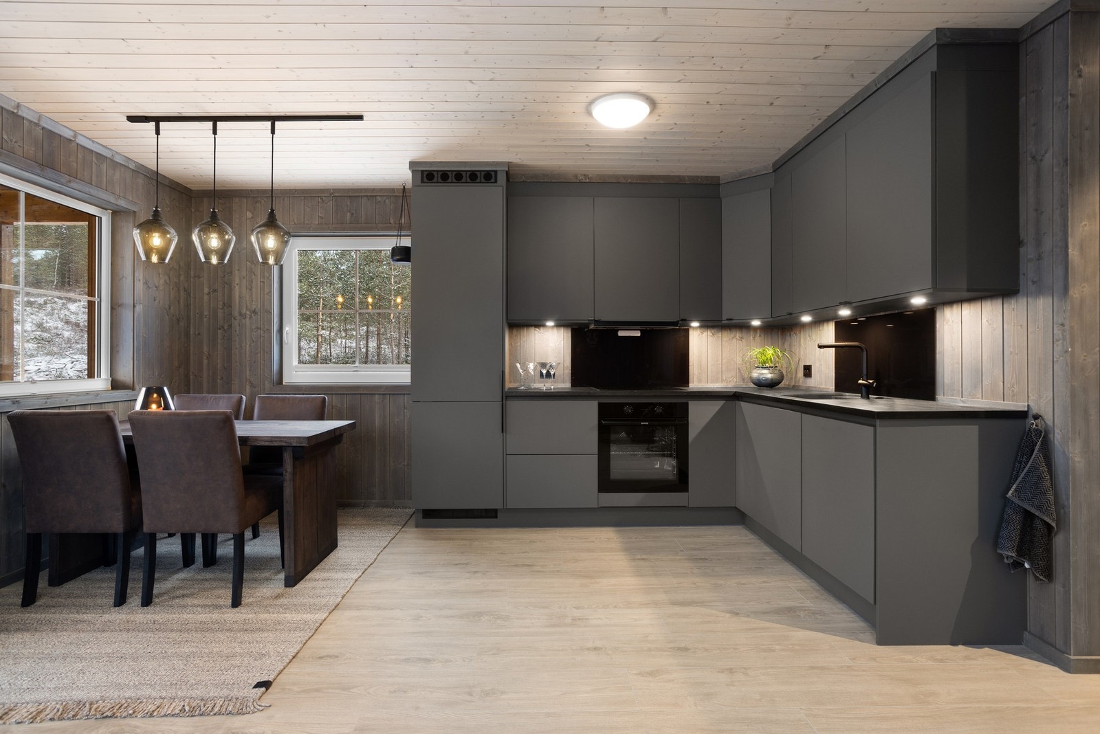 Kjøkkeninnredningen fra HTH har sorte fronter, stilig benkeplate i heltre eik og integrerte hvitevarer. Galleribilde