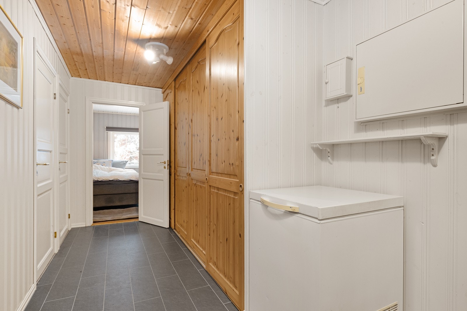 Praktisk mellomgang med flislagt gulv og rikelig med oppbevaringsplass Galleribilde