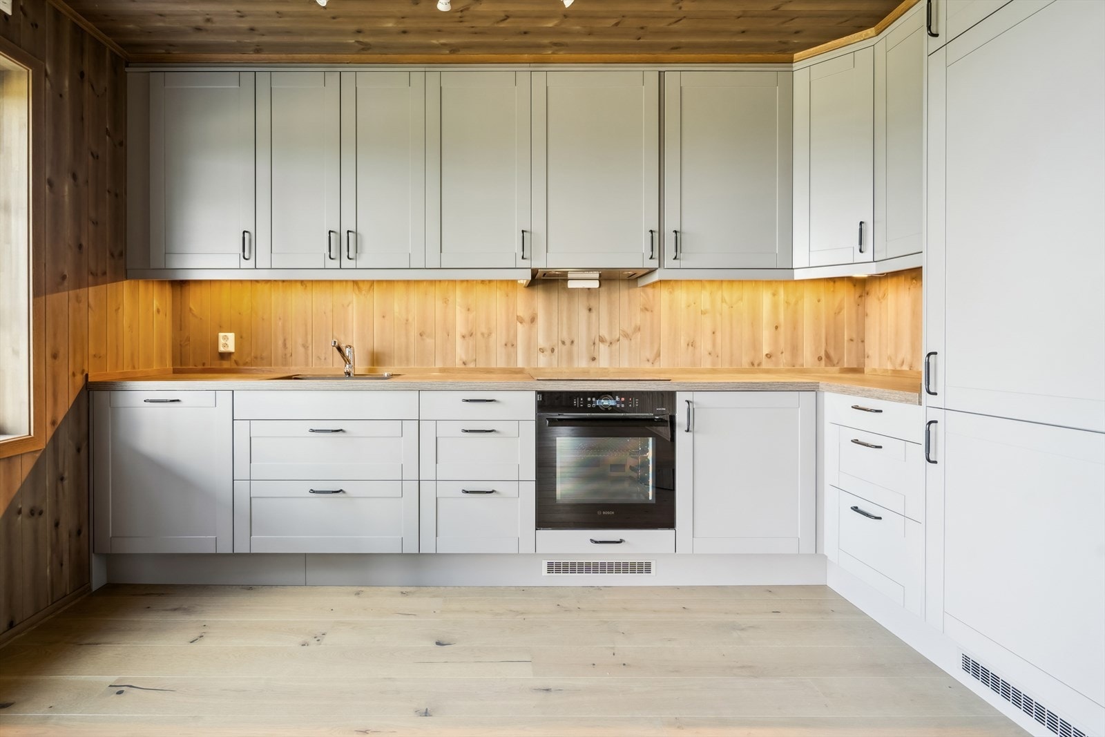 Moderne kjøkkeninnredning med profilerte fronter og benkeplate av laminat. Galleribilde