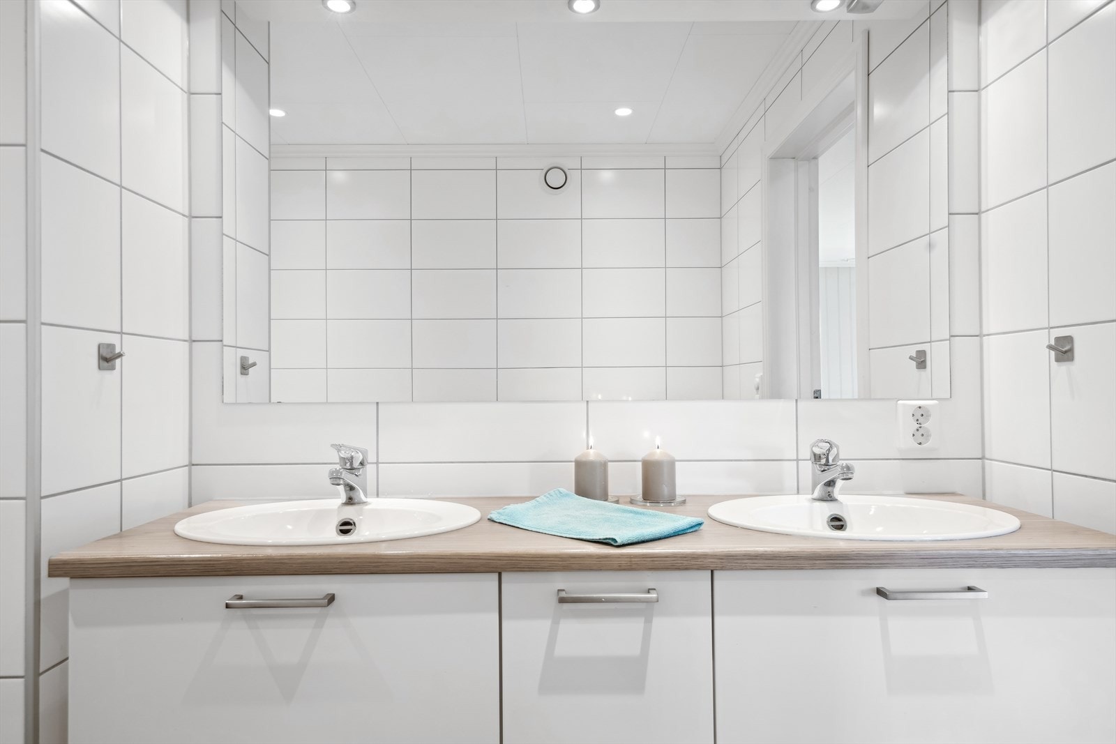 Moderne bad med dobbel servant, nøytrale farger og gode lysforhold, perfekt for en frisk start på dagen. Galleribilde