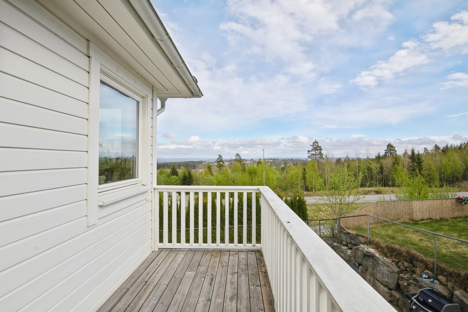 Lys og tiltalende veranda med noe utsikt over naturskjønne omgivelser. Galleribilde