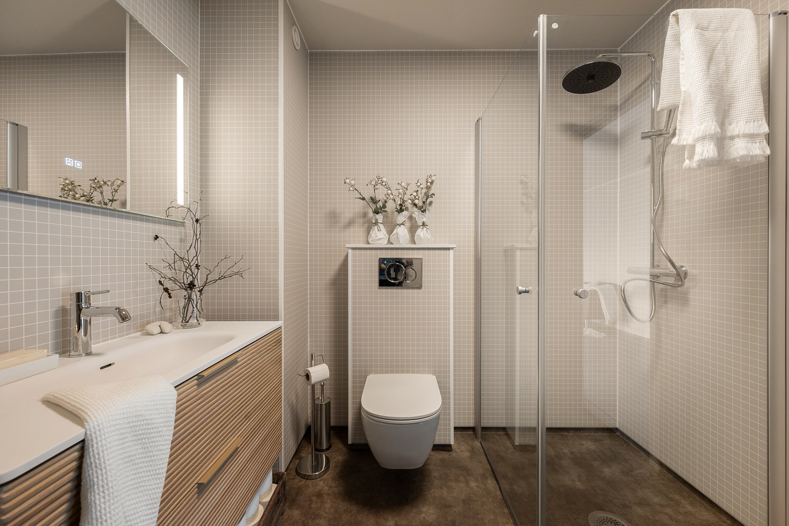 Det er valgt en delikat og nøytral stil på badet med våtromsplater på veggene og belegg på gulvet. Et funksjonelt rom. Galleribilde