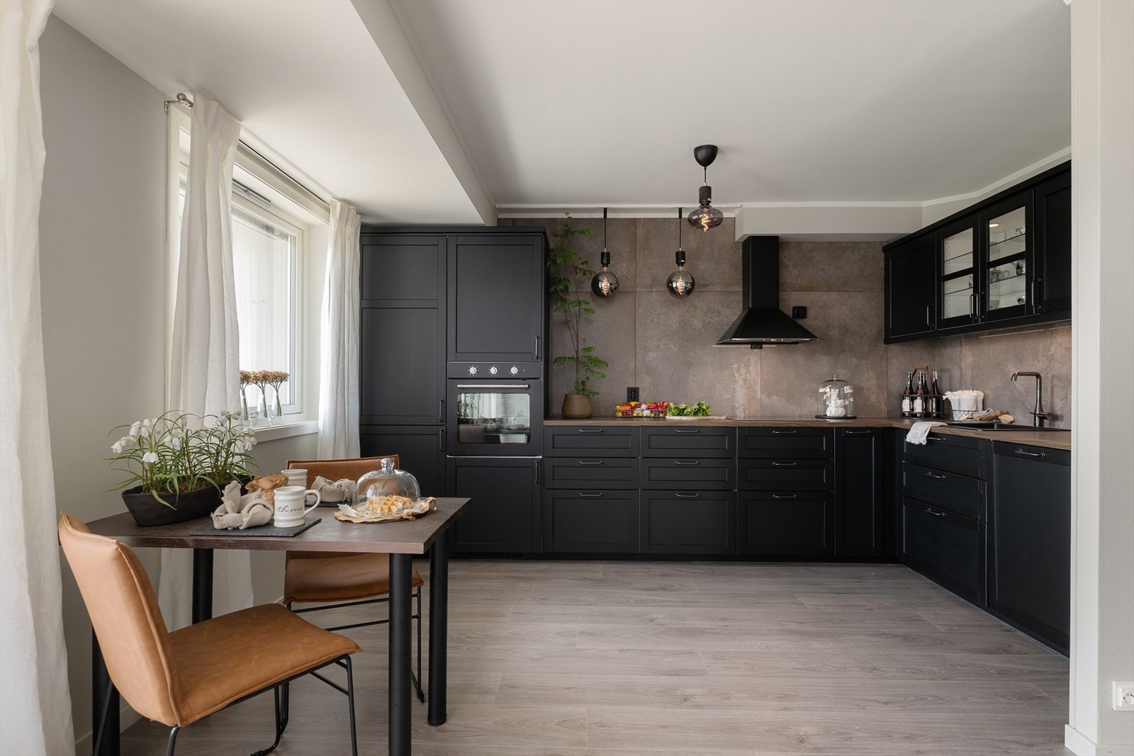 Kjøkkenet er nytt, lekkert og moderne med svarte fronter som står fint til de lune veggene. Rause fliser over benk gir et elegant uttrykk. Galleribilde