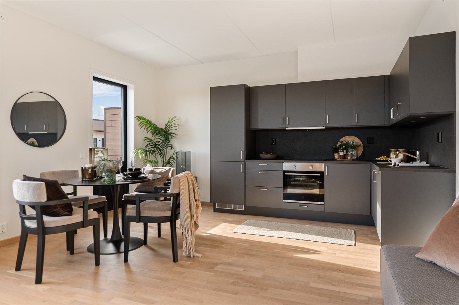 Kjøkkeninnredningen er stilren med mørke, slette fronter og laminat benkeplate. Galleribilde