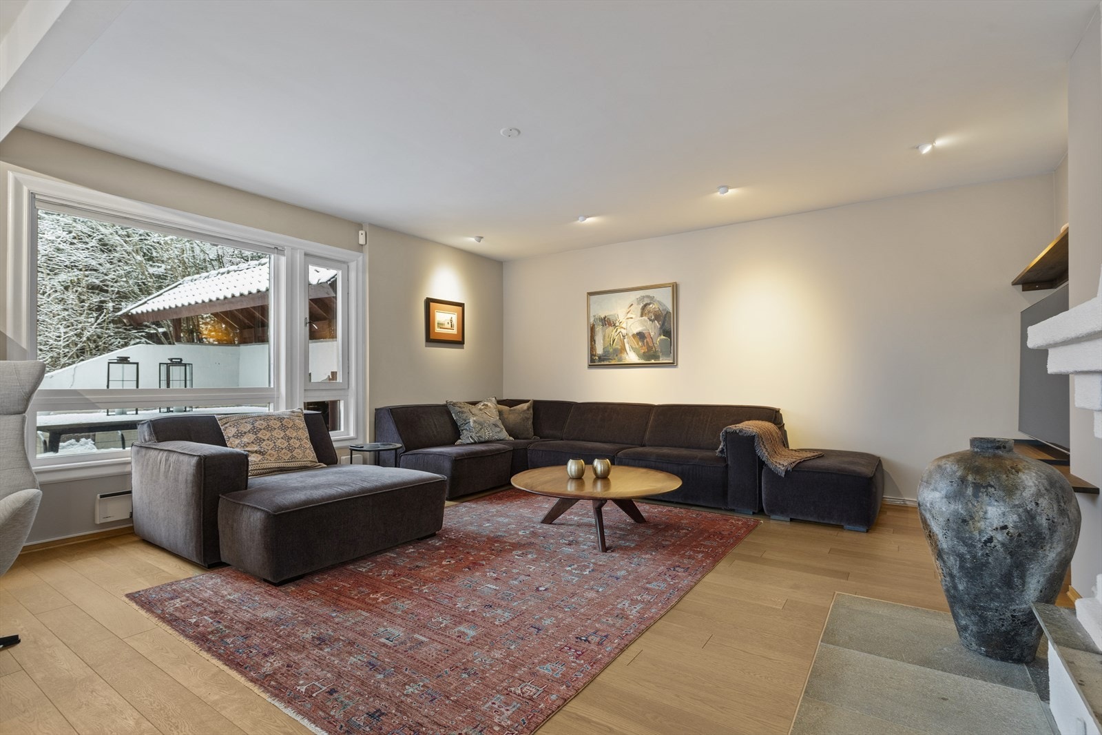 Romslig, lys og hyggelig stue med peis. Stort vindu ut mot privat og skjermet uteplass/terrasse. Galleribilde