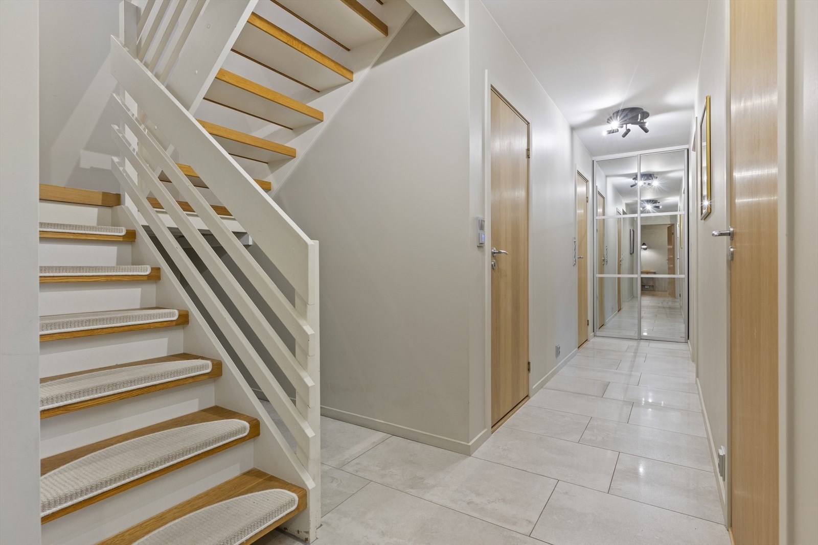 Praktisk lagringsplass under trappen. Skyvedørsgarderobe i enden av gangen. Galleribilde