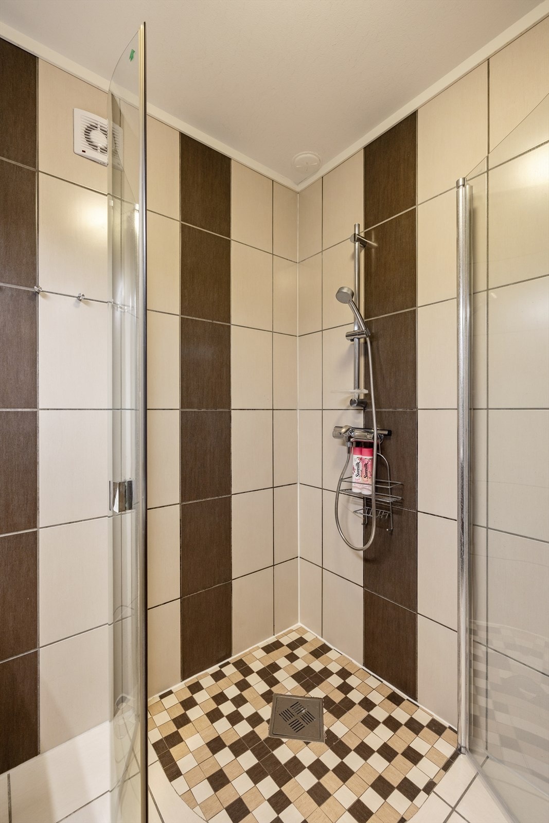 Badet har fliser på gulv og vegger, med malte plater i himlingen. Det er varme i gulvet. Innredningen består av en servant med underskap, speilskap og dusjdører. Galleribilde