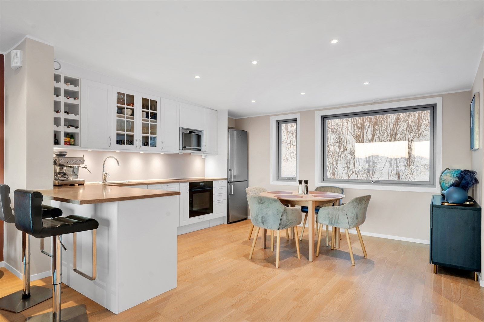 Lyst og pent kjøkken med flott bar-løsning og integrerte hvitevarer. Galleribilde