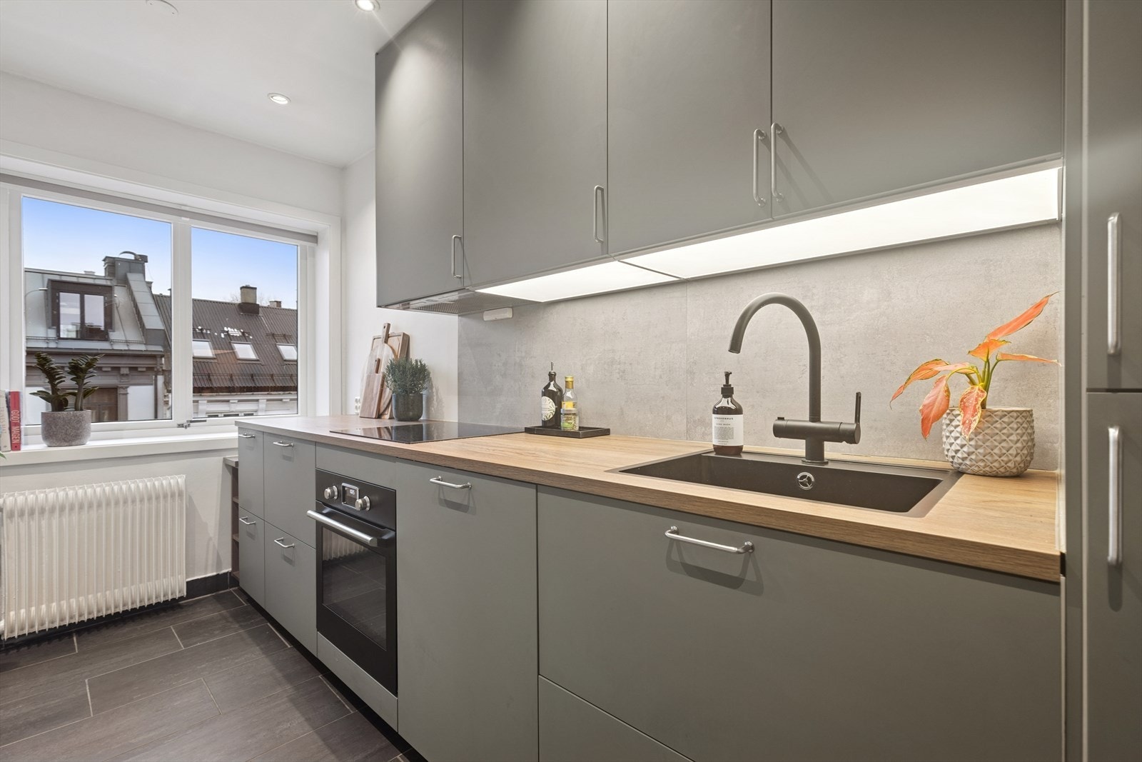 Innredningen består av glatte fronter på skuffer og skap, og laminat benkeplate. Kjøkkenet består av tidløse farger. Galleribilde