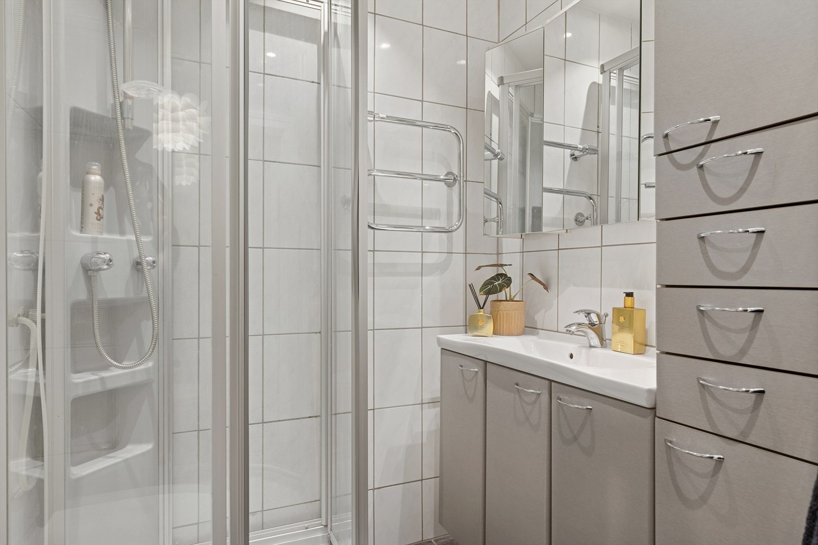 Eldre bad med fliser på vegger og gulv, med varmekabler i gulvet. Downlights i taket. Galleribilde