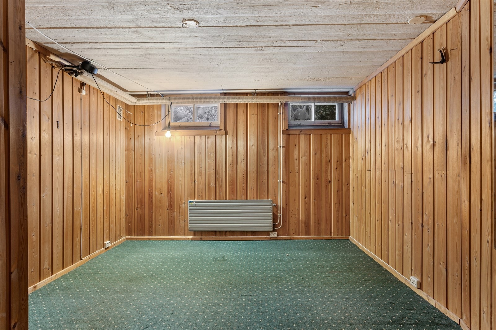 Rom med teppegulv og panelvegger. Rommet oppfyller ikke kravene til varig opphold grunnet rømningsvei. Galleribilde