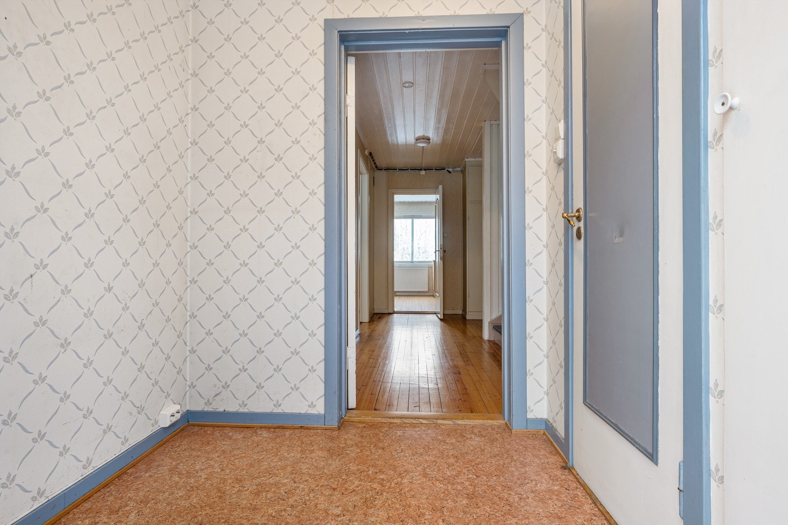 Boligens entré har belegg på gulv og tapeserte veggflater. Galleribilde