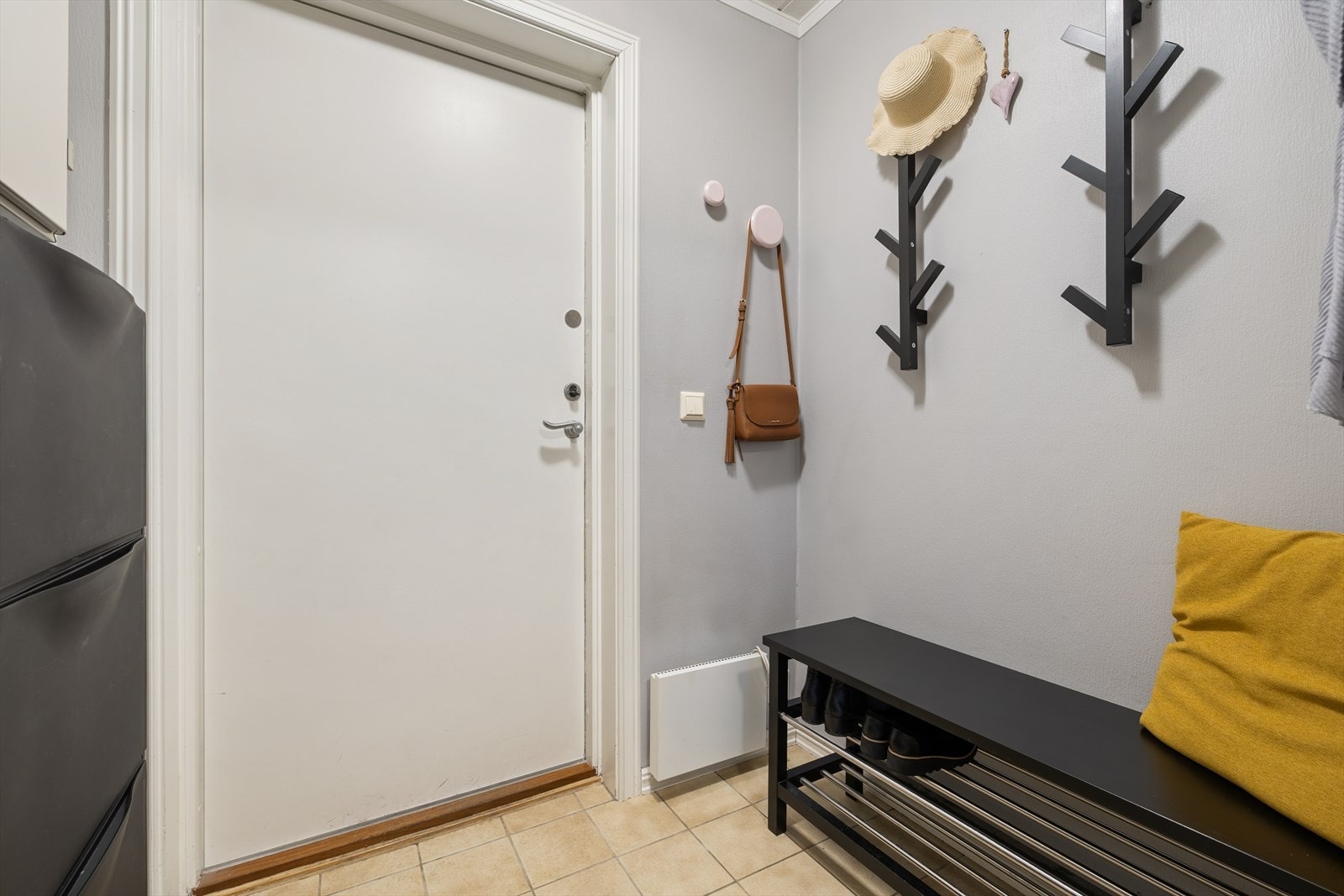 Fliser på gulvet gir et praktisk og lettstelt inngangsparti med plass til sko og yttertøy. Galleribilde