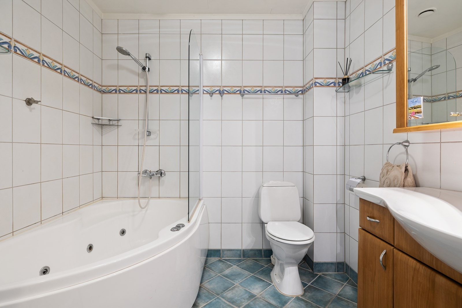 Innredningen har glatte fronter med heldekkende servant og speilskap med integrert belysning. Videre er badet utstyrt med gulvstående toalett og badekar med termostatstyrt blandebatteri. Galleribilde