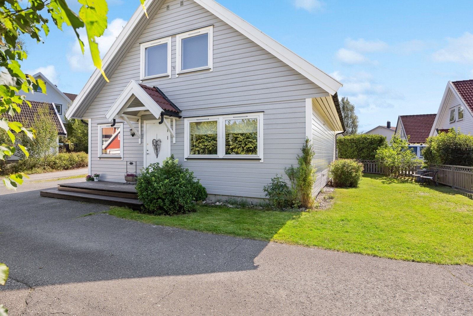 Inngangspartiet er pent anlagt med en liten tretrapp og beplantning. Galleribilde