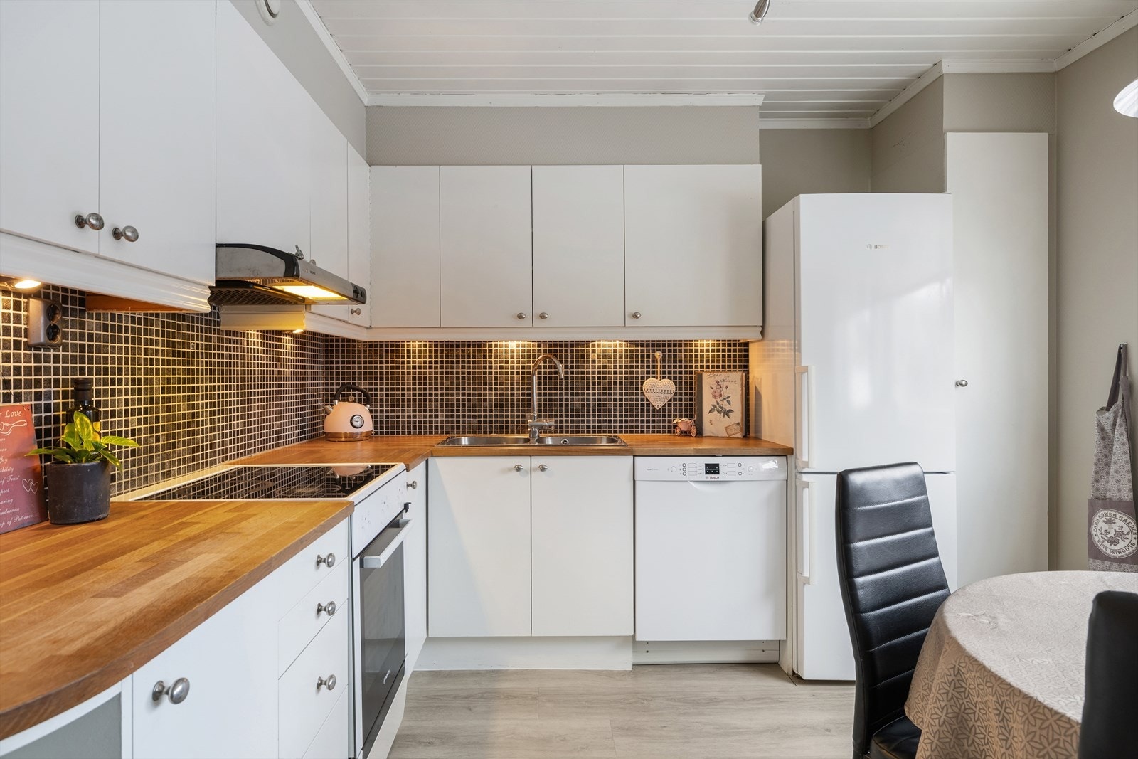 Kjøkkenet er fra byggeår og har en pen innredning med hvite, glatte fronter samt heltre benkeplate med nedfelt oppvaskkum i rustfritt stål. Galleribilde