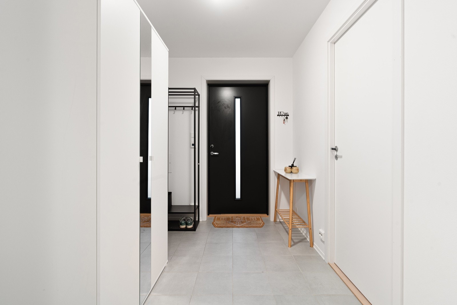 Velkommen inn - flislagt entré med god plass for garderobeskap.