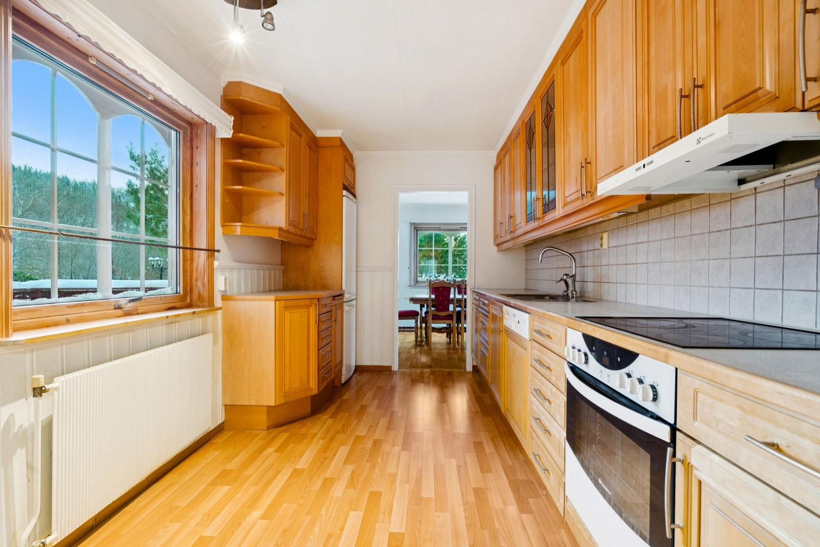 Benkeplaten er av laminat med kantlist av tre og nedfelt kjøkkenvask i rustfritt stål Galleribilde