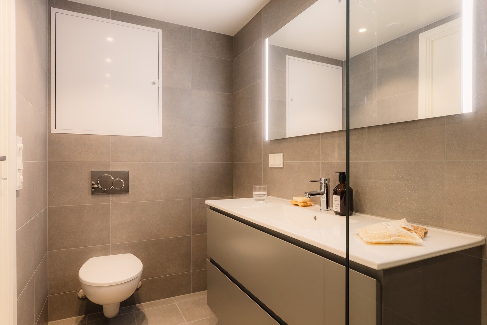 Baderommet er utført i samme delikate og gjennomførte stil som leilighetens øvrige baderom, med tidløse materialvalg og høy kvalitet. Galleribilde