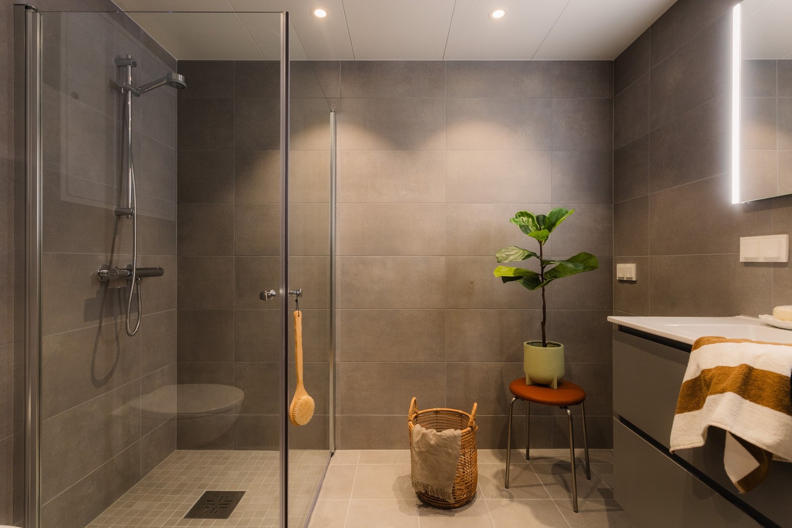 I tilknytning til entréen finner du ett av boligens to delikate baderom, praktisk plassert for både beboere og gjester. Galleribilde