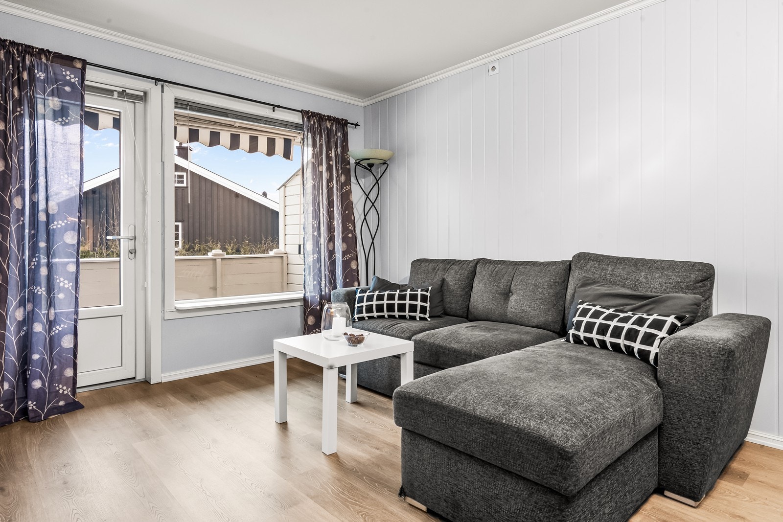 Store vinduer i stuen gir godt lysinnslipp og utsikt til uteområdet. Galleribilde