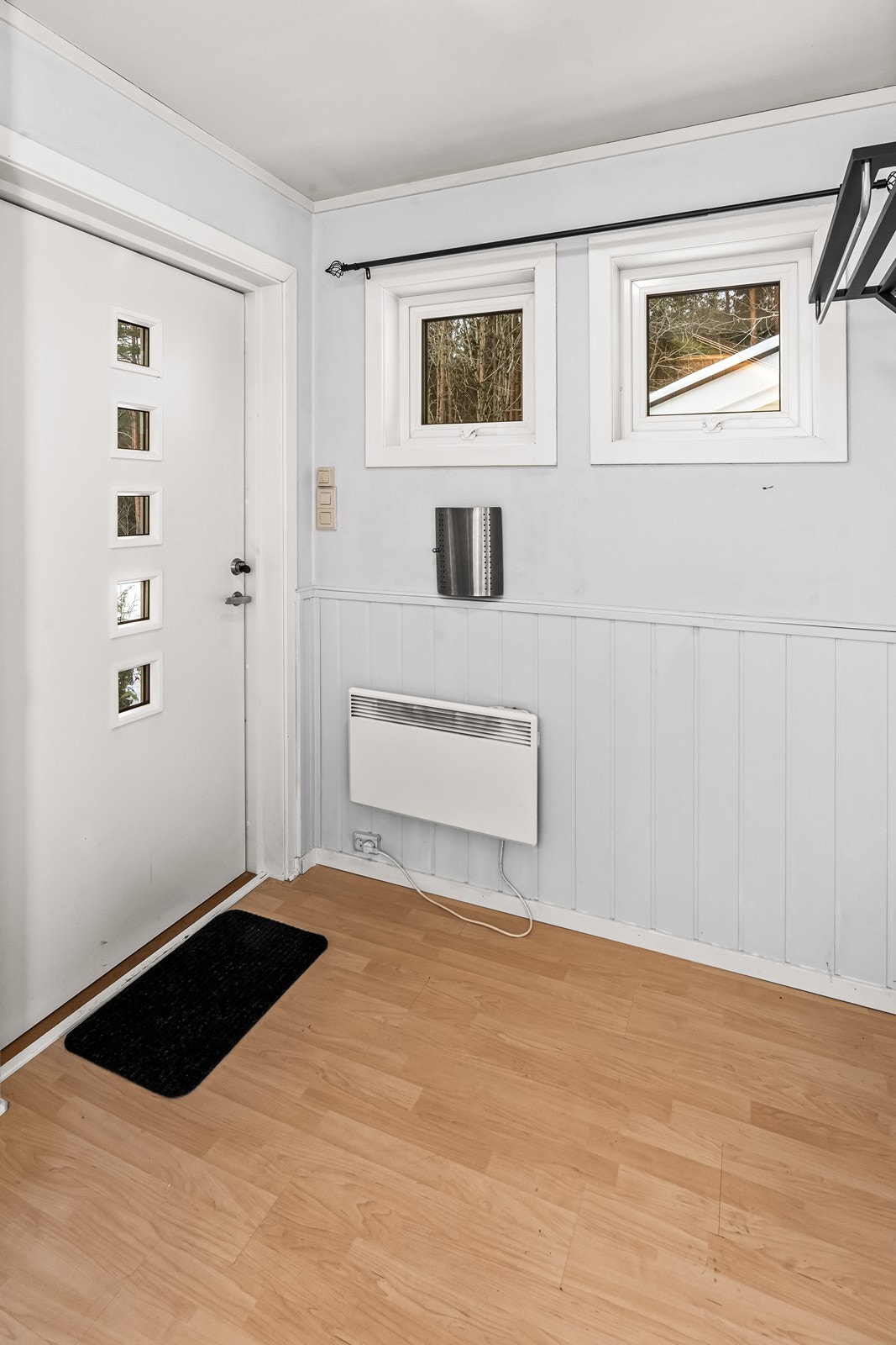 Malt ytterdør med glassfelt fra 2018 gir lysinnslipp i entréen. Laminatgulvet ble lagt i 2022, og veggene har oppgradert smartpanel. Galleribilde