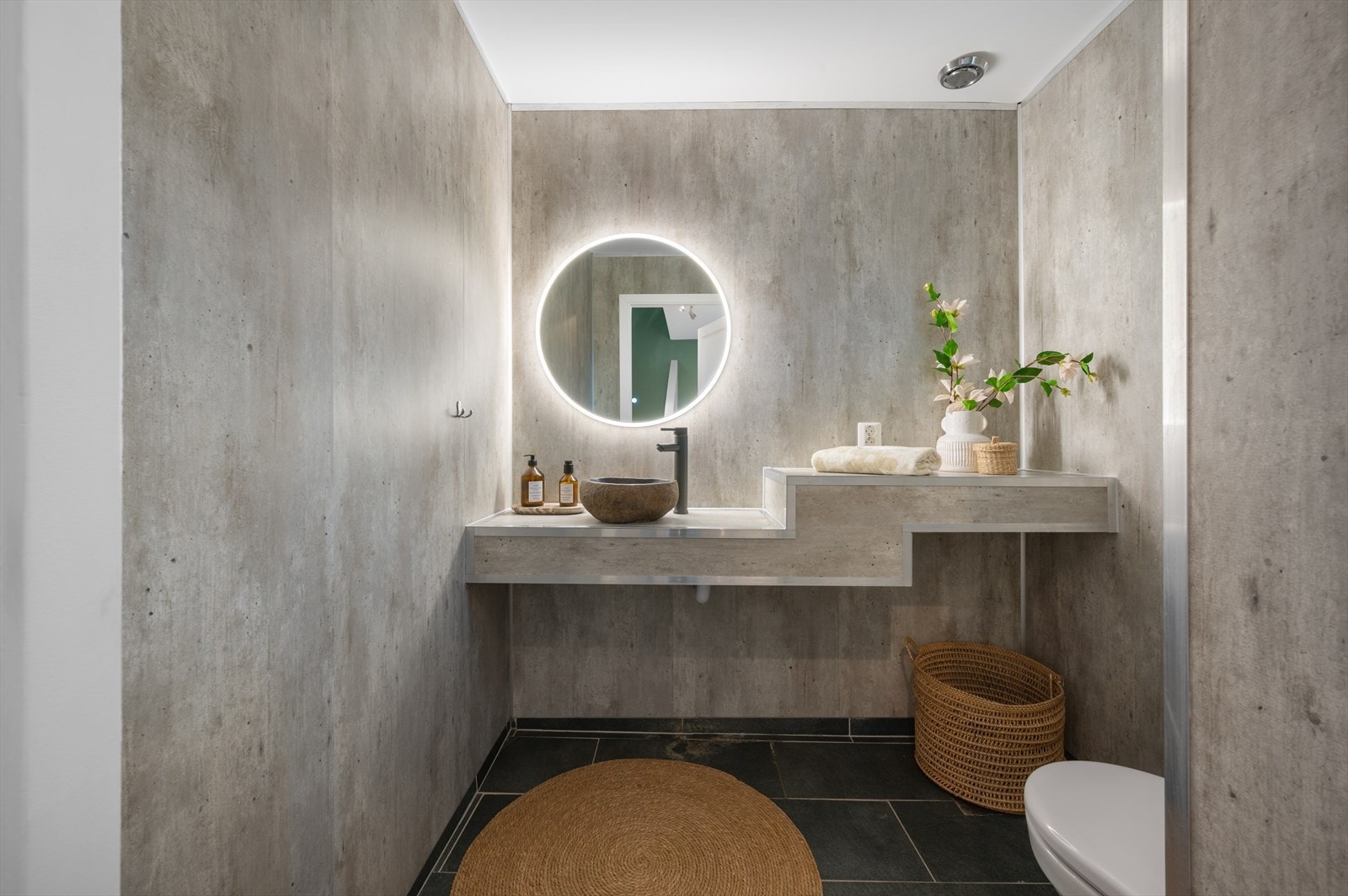 - WC måler 2,7m² og har plassbygget baderomsinnredning med toppmontert designvask i stein, speil m/belysning og toalett - Galleribilde