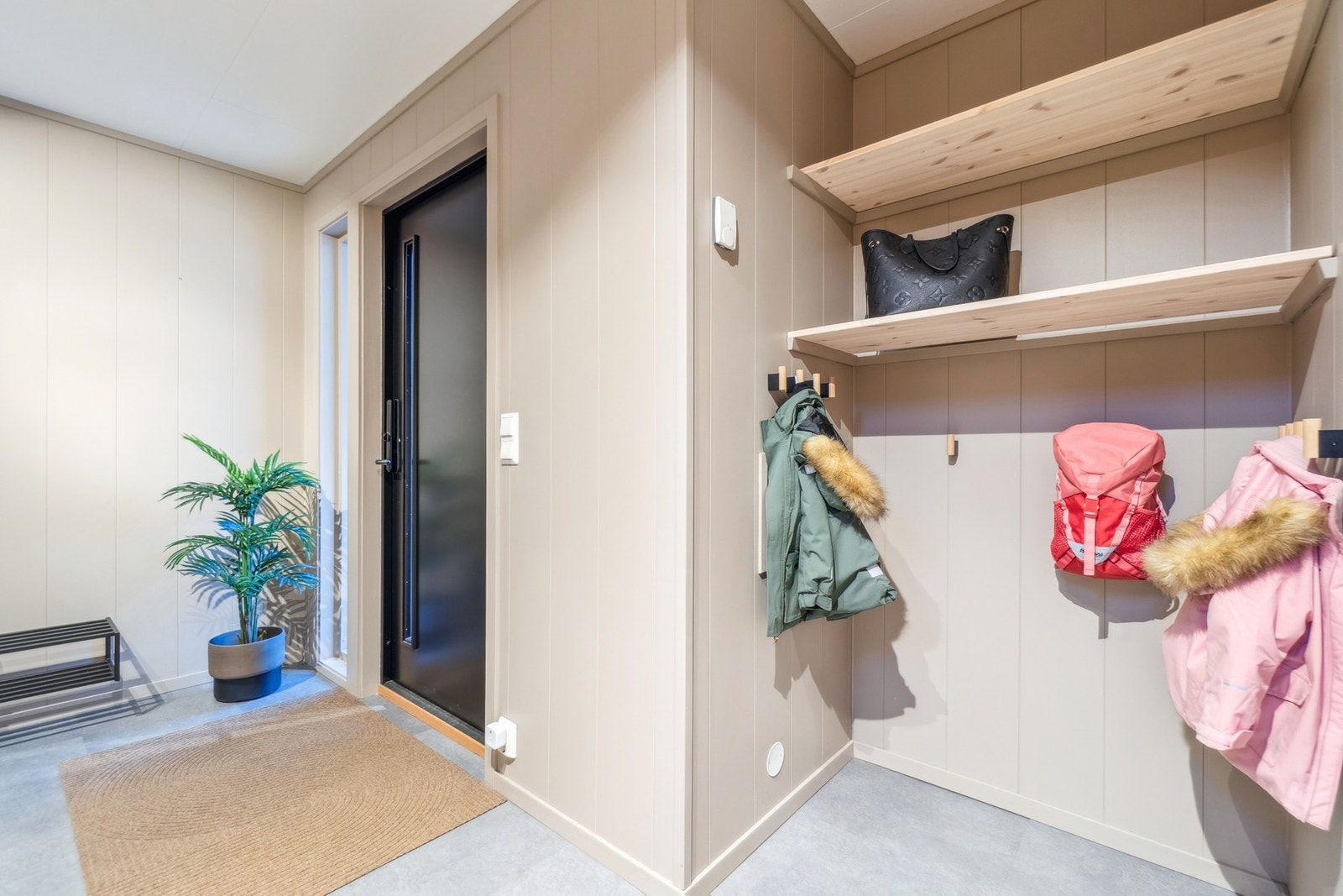 I entréen er det god plass for yttertøy i garderobeskap og åpen garderobeløsning. I 2022 ble det satt inn ny ytterdør som gir fasaden et helhetlig inntrykk. Galleribilde