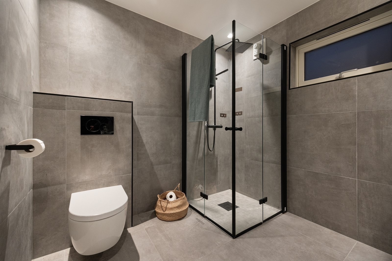 Baderommet er innredet med dobbelservant i møbel, speil med lys, vegghengt toalett og et praktisk dusjhjørne. Galleribilde